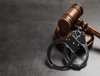 A pair of handcuffs with a gavel is in the image.